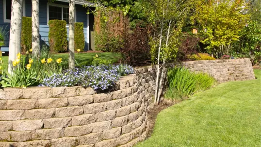 A lush, tiered garden showcases curving stone retaining walls.